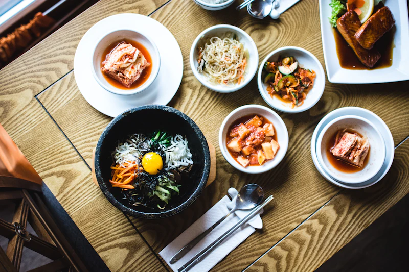 비빔밥과 반찬이 놓인 나무 테이블